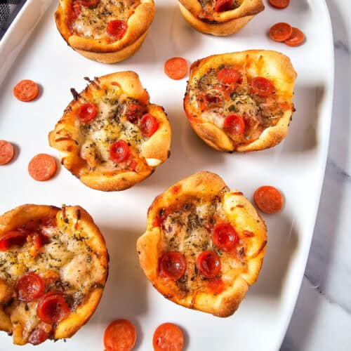 a plate of pepperoni pizza bites on a marble surface