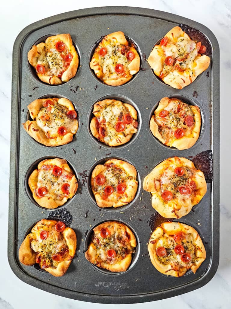 Cheesy pepperoni pizza bites baked in a muffin pan.