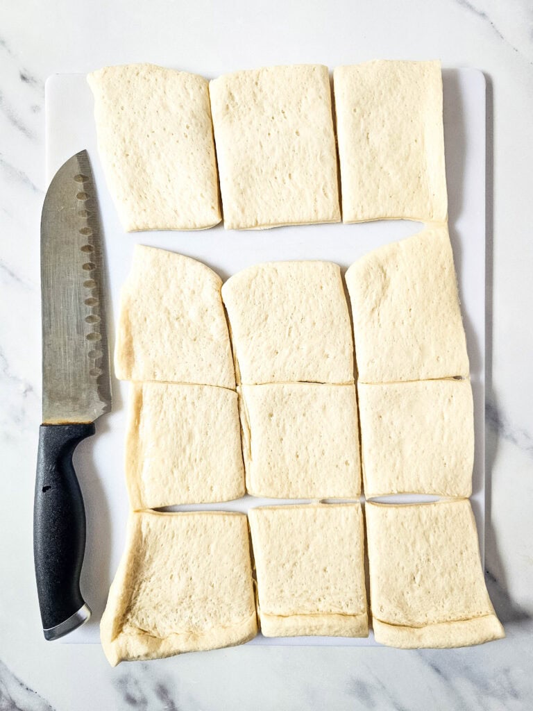 Pizza dough cut into squares getting ready to assemble pizza bites.