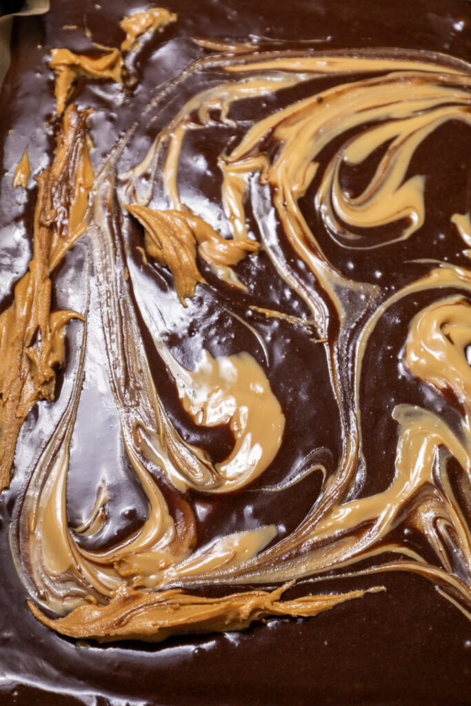 Swirling peanut butter into brownie batter before baking.